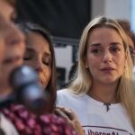 La esposa del dirigente opositor venezolano Leopoldo López, Lilian Tintori, escucha a la esposa del alcalde mayor de Caracas Antonio Ledezma, Mitzi Capriles