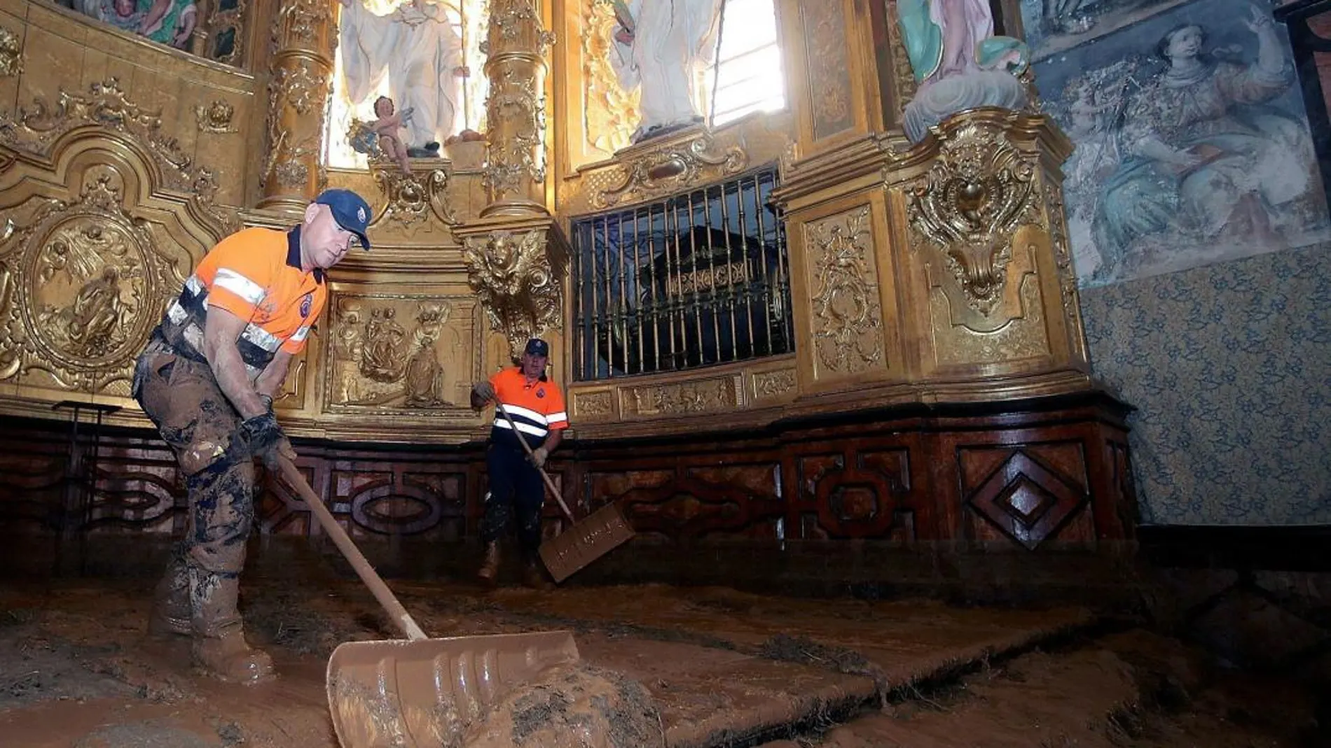 Varios operarios durante las labores de limpieza del Monastario cisterciense de Santa María de Huerta (Soria), que se encuentra cubiertas de barro tras las últimas tormentas registrada