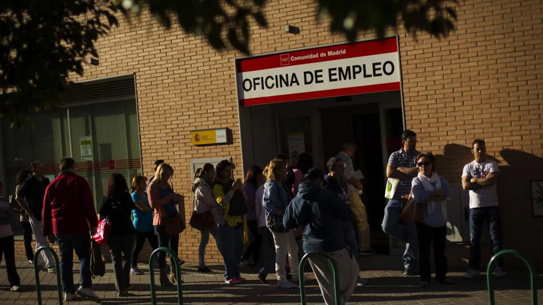 Desempleados hacen cola ante una oficina de desempleo en Madrid.