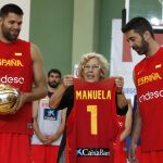 La alcaldesa de Madrid, Manuela Carmena, recibe de manos de los jugadores Felipe Reyes y Juan Carlos Navarro (d), una camiseta del equipo con su nombre tras asistir al entrenamiento de la selección española de baloncesto.