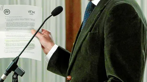 Vox ha aceptado descartar algunos de los elementos que forman parte del núcleo de su programa. Se los reserva para más tarde, evidentemente. En la imagen, el documento pactado ayer en manos de Juanma Moreno
