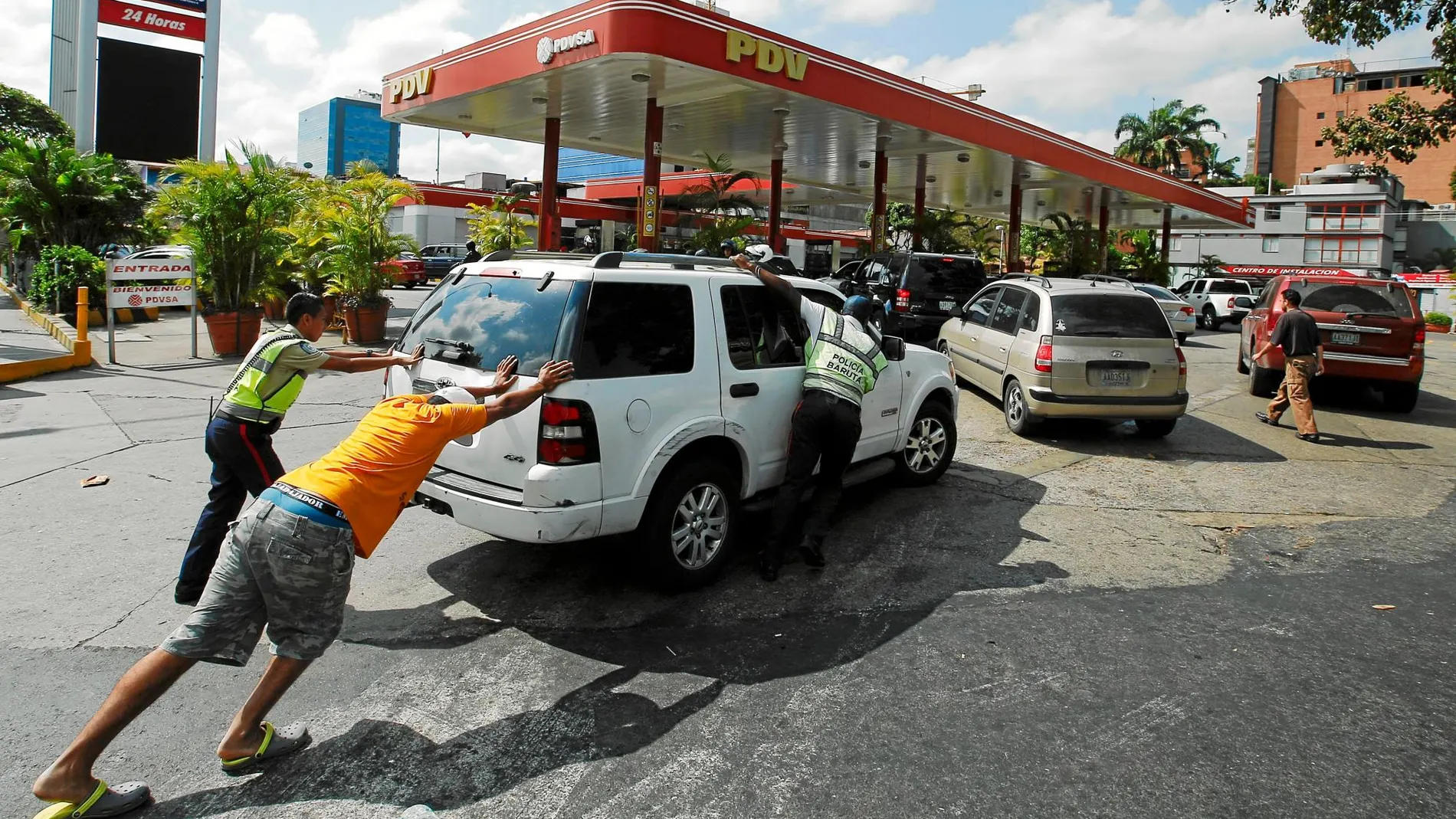 Varios venezolanos arrastran un vehículo hasta una de las pocas gasolineras de Caracas que cuentan con un generador eléctrico en medio del apagón / Reuters