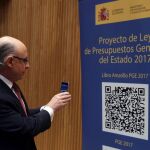 El ministro de Hacienda, Cristóbal Montoro, escanea con el móvl el código QR del proyecto de Ley de Presupuestos Generales del Estado (PGE) para 2017.