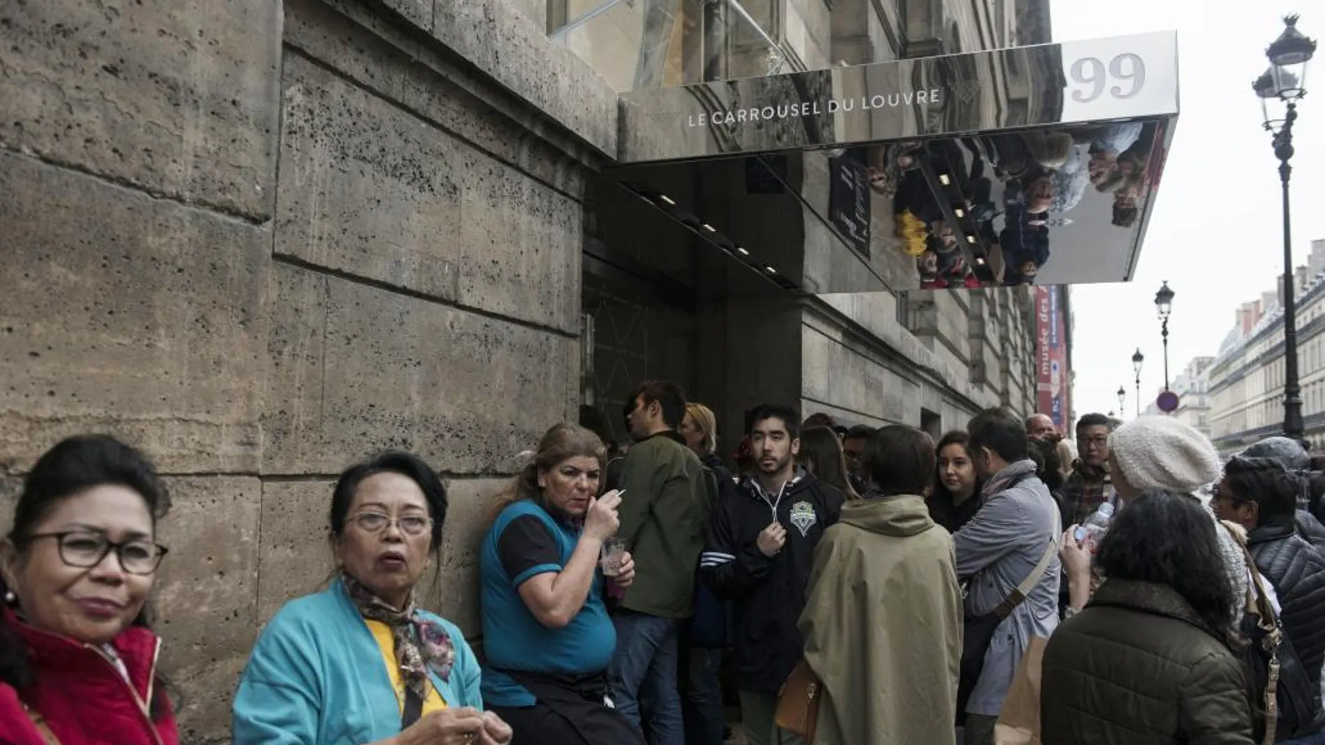 Gente a las puertas de Carrousel du Louvre donde Macron celebrará esta noche la velada para recibir los resultados de la segunda vuelta de las elecciones