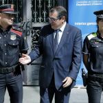 El conseller de Interior, Jordi Jané (c), junto a una agente de la Policía Local (d) y un Mosso d'Escuadra (d) durante el acto en que se han presentado los nuevos uniformes.
