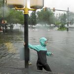 Una mujer trata de atravesar una carretera inundada en el parque «Union Point» de New Bern en Carolina del Norte, ayer