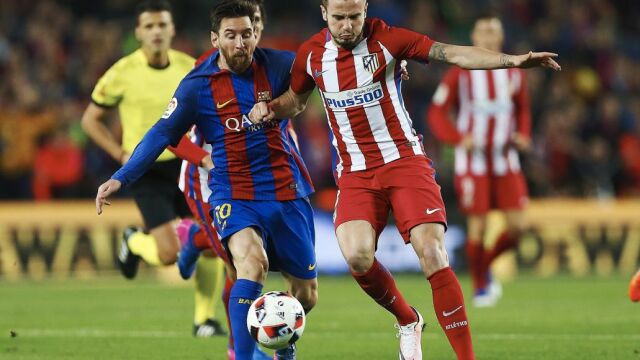 El delantero argentino del FC Barcelona Leo Messi disputa un balón con el centrocampista del Atlético de Madrid Saúl Ñíguez