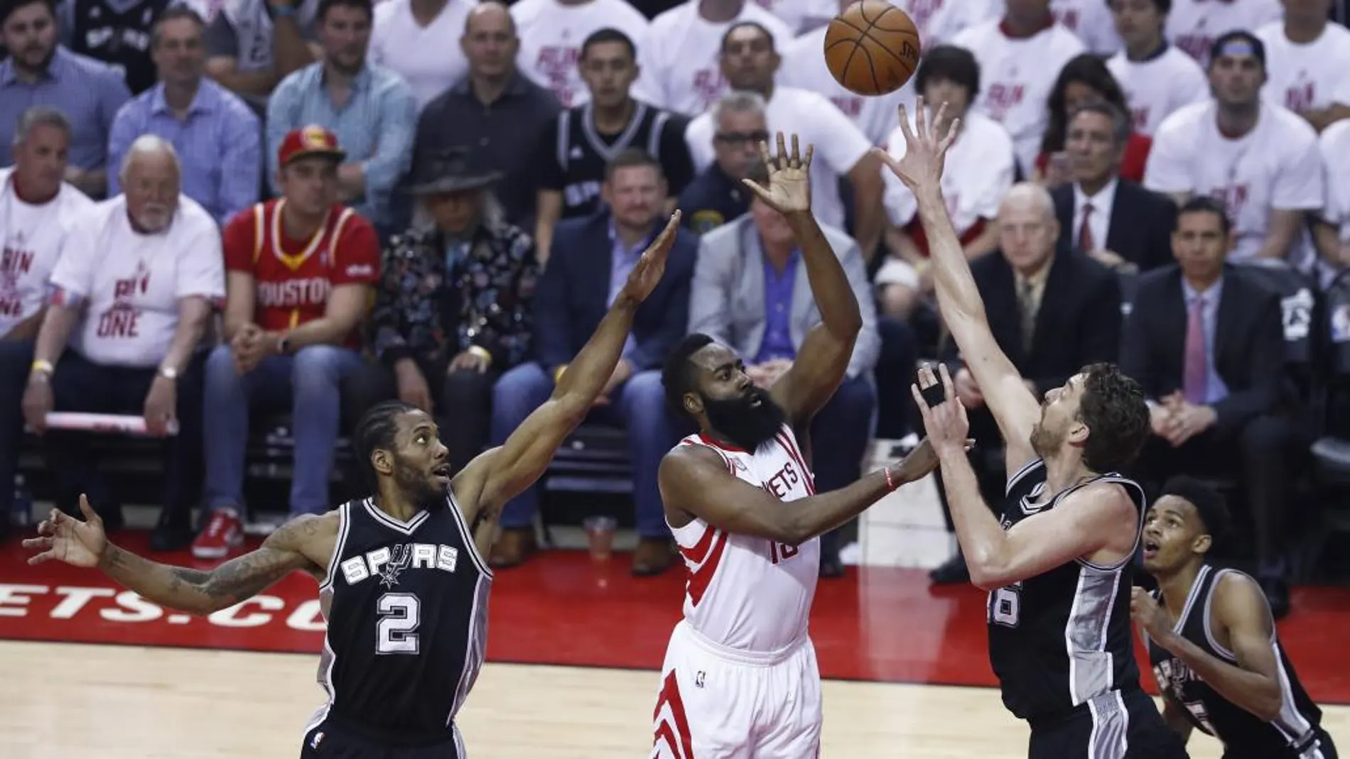 El jugador de Houston Rockets James Harden intenta encestar ante la oposición de Pau Gasol