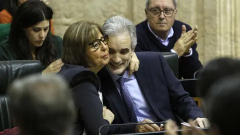 La consejera Adelaida de la Calle tiene un gesto cariñoso con Aquilino Alonso en el Parlamento andaluz
