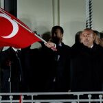 El ministro de Exteriores turco, Mevlut Cavusoglu (C), ondea la bandera turca ante seguidores del Gobierno de ese país, en los jardines del Consulado de Turquía en Hamburgo