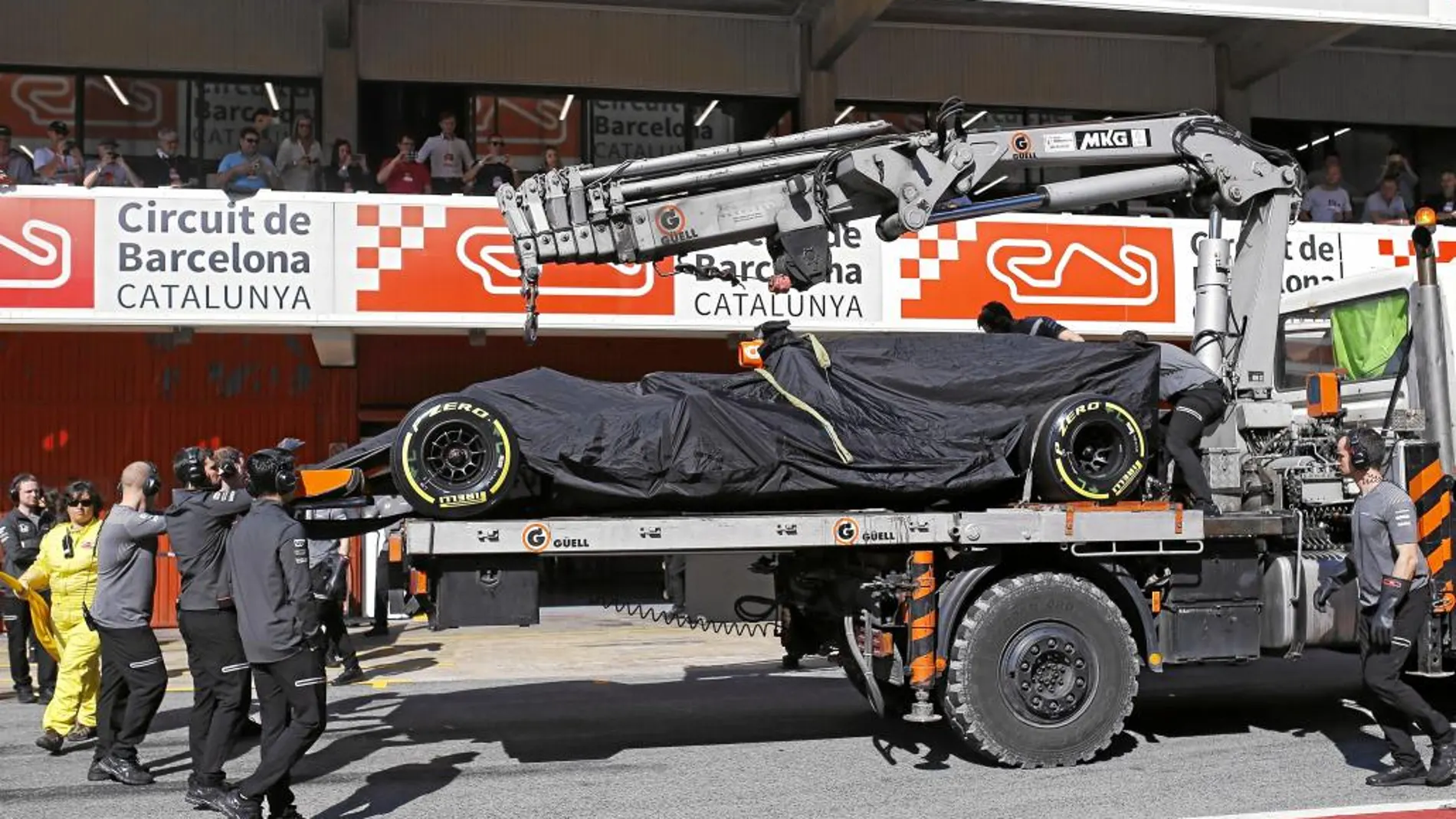 El MCL32 de Alonso vuelve a boxes en una grúa tras romperse