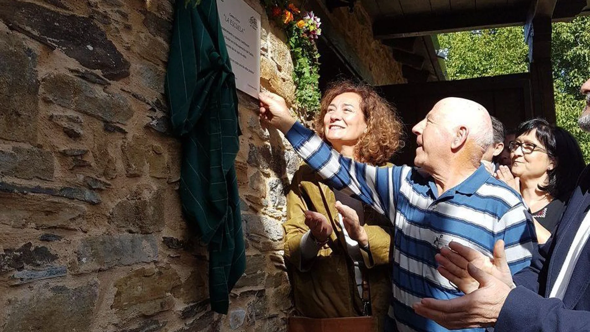 Santos Mateos, presidente de la Asociación de Vecinos de San Adrián de Valdueza, descubre la placa que recuerda la inauguración del centro cívico «La Escuela», en presencia de la alcaldesa de Ponferrada, Gloria Merayo, y del vicepresidente de la Diputación de León para el Bierzo, Ángel Calvo