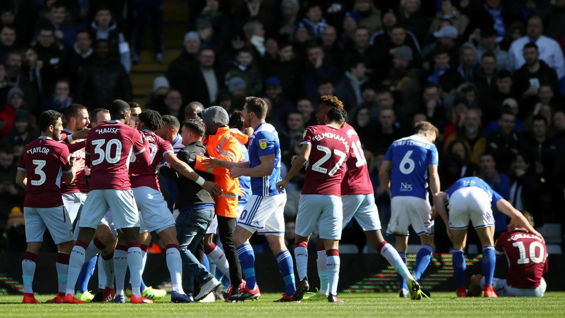 Los jugadores del Aston Villa y Birmingham City, junto a las fuerzas de seguridad, atrapan al aficionado que agredió al jugador del Aston Villa Jack Grealish