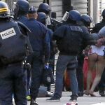 Los agentes del cuerpo especial de Policía trasladan a uno de los ocho detenidos ayer en el barrio de Saint Denis