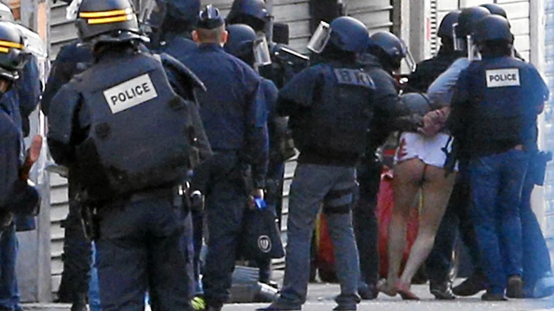 Los agentes del cuerpo especial de Policía trasladan a uno de los ocho detenidos ayer en el barrio de Saint Denis
