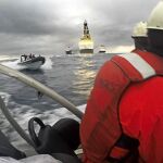 Fotografía facilitada por Greenpeace de dos activistas en una de sus lanchas y otra de la Armada española durante la protesta frente a la plataforma Rowan Renaissance contra las prospecciones petrolíferas.