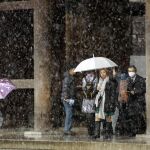 Turistas caminan bajo la nieve de Tokio junto al templo Meiji