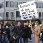 La artista sueca Milo Moire se manifiesta sin ropa mientras sostiene un cartel que reza "¡Respétanos! ¡No somos carne de presa ni aunque estemos desnudas!"en la plaza central de Colonia (Alemania).