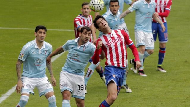 El jugador del Celta de Vigo Jonny y Pablo Pérez, del Sporting de Gijón, saltan por un balón