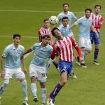 El jugador del Celta de Vigo Jonny y Pablo Pérez, del Sporting de Gijón, saltan por un balón