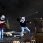 AVarias palestinos lanzan piedras contra el ejército israelí en el asentamiento de Beit El, cerca de Ramala