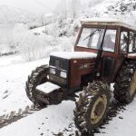 En la imagen, un tractor circula por una carretera cubierta de nieve en el pueblo de Brañas, en As Nogais