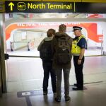 Un policía conversa con viajeros en el aeropuerto de Gatwick el sábado
