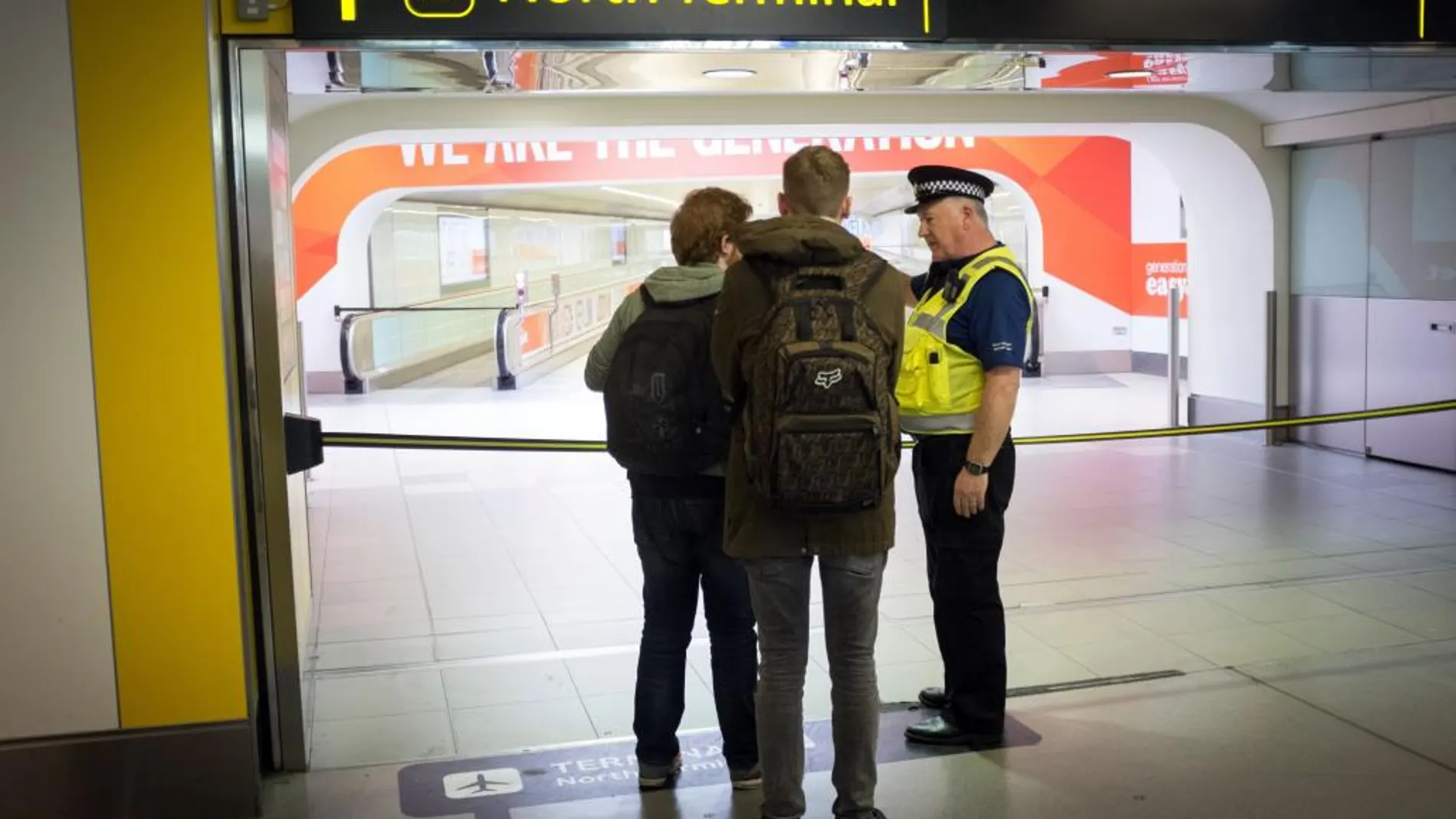 Un policía conversa con viajeros en el aeropuerto de Gatwick el sábado