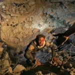 Un miembro de la defensa civil intenta salir del lugar de impacto de un ataque aéreo en Saraqeb, en la provincia controlada por los rebeldes de Idlib