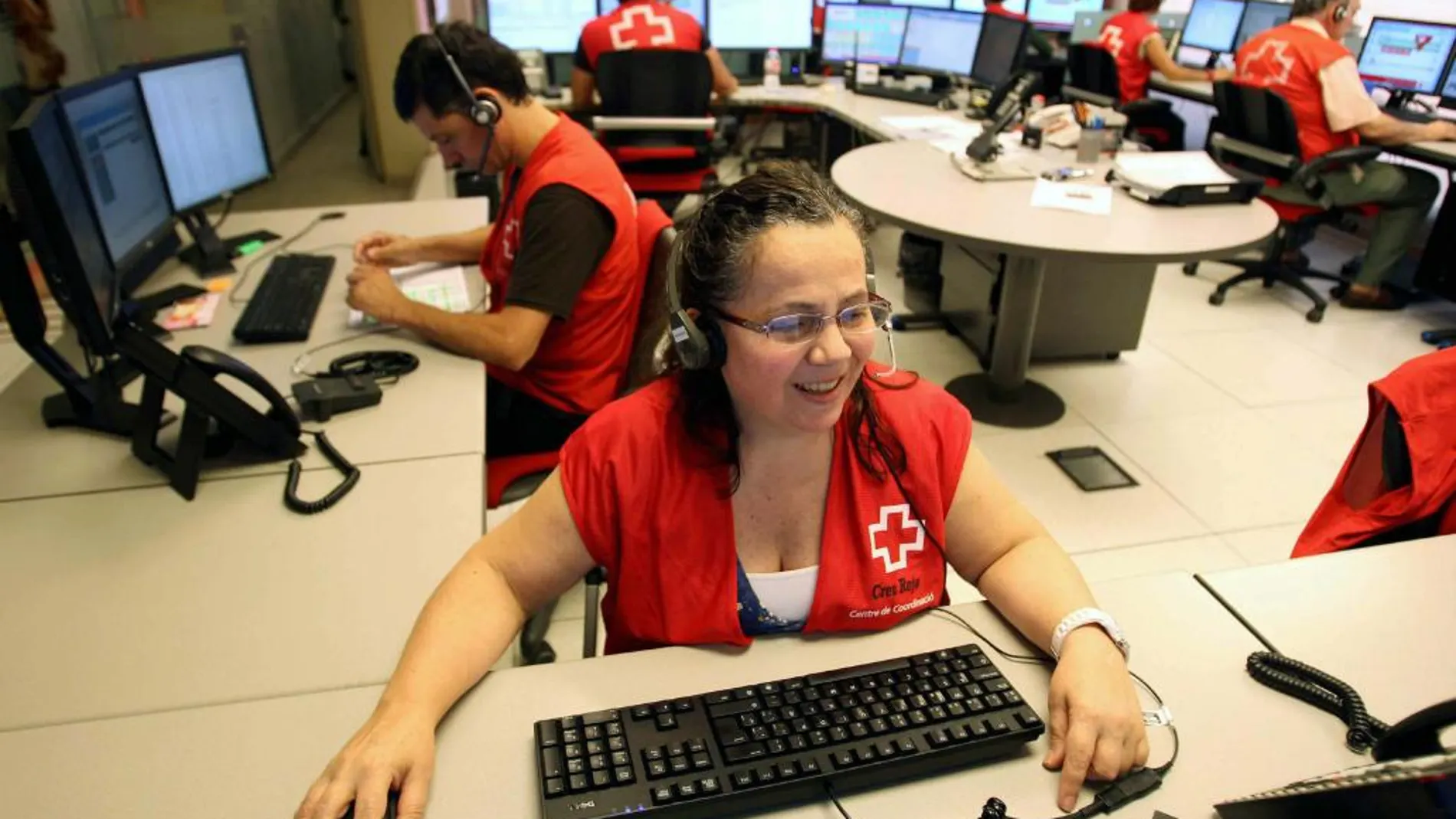 Una operadora atiende a una anciana desde el centro de coordinación de la Cruz Roja, en una imagen de archivo