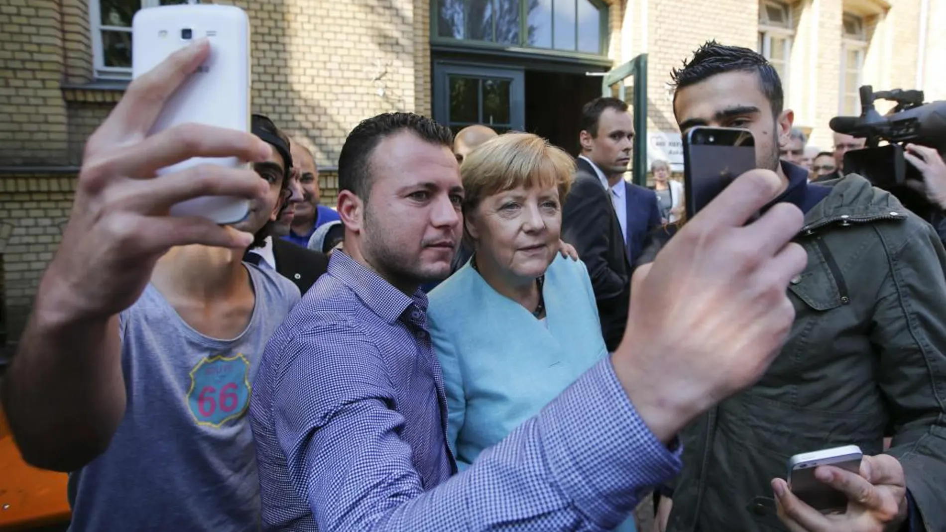 Angela Merkel, con tres refugiados en un centro de Berlín