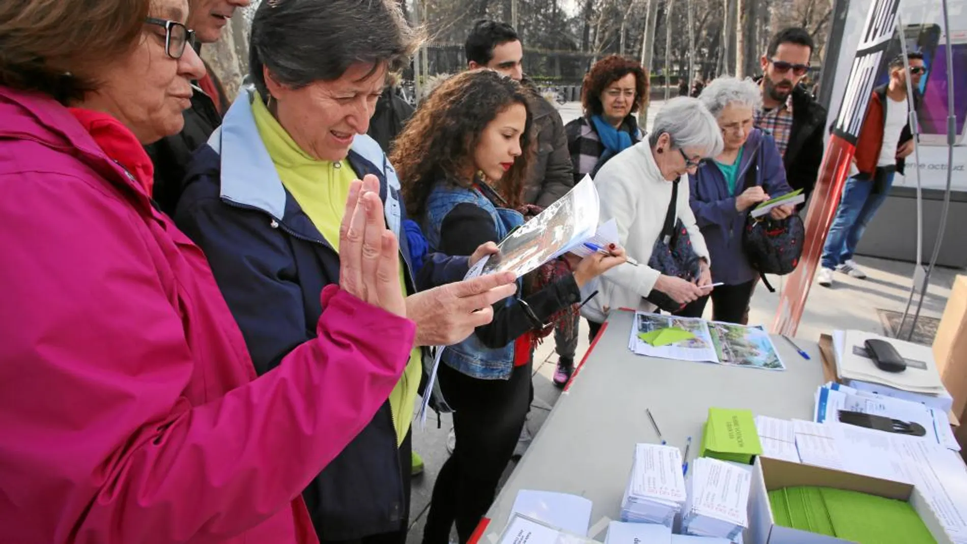Un grupo de vecinos votando e informándose en la mesa de votación instalada durante el fin de semana en la Plaza de la Independencia