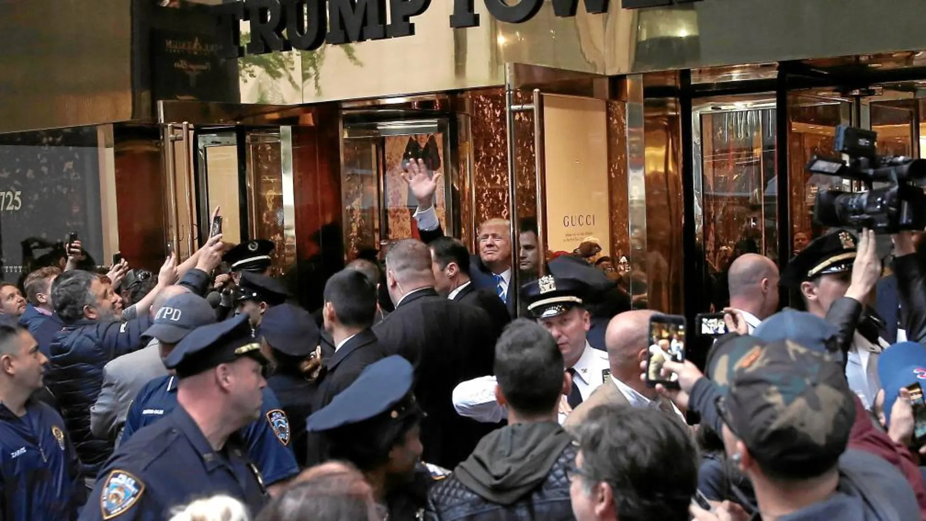 Trump saluda a sus seguidores a la salida de uno de sus edificios en Nueva York, ayer
