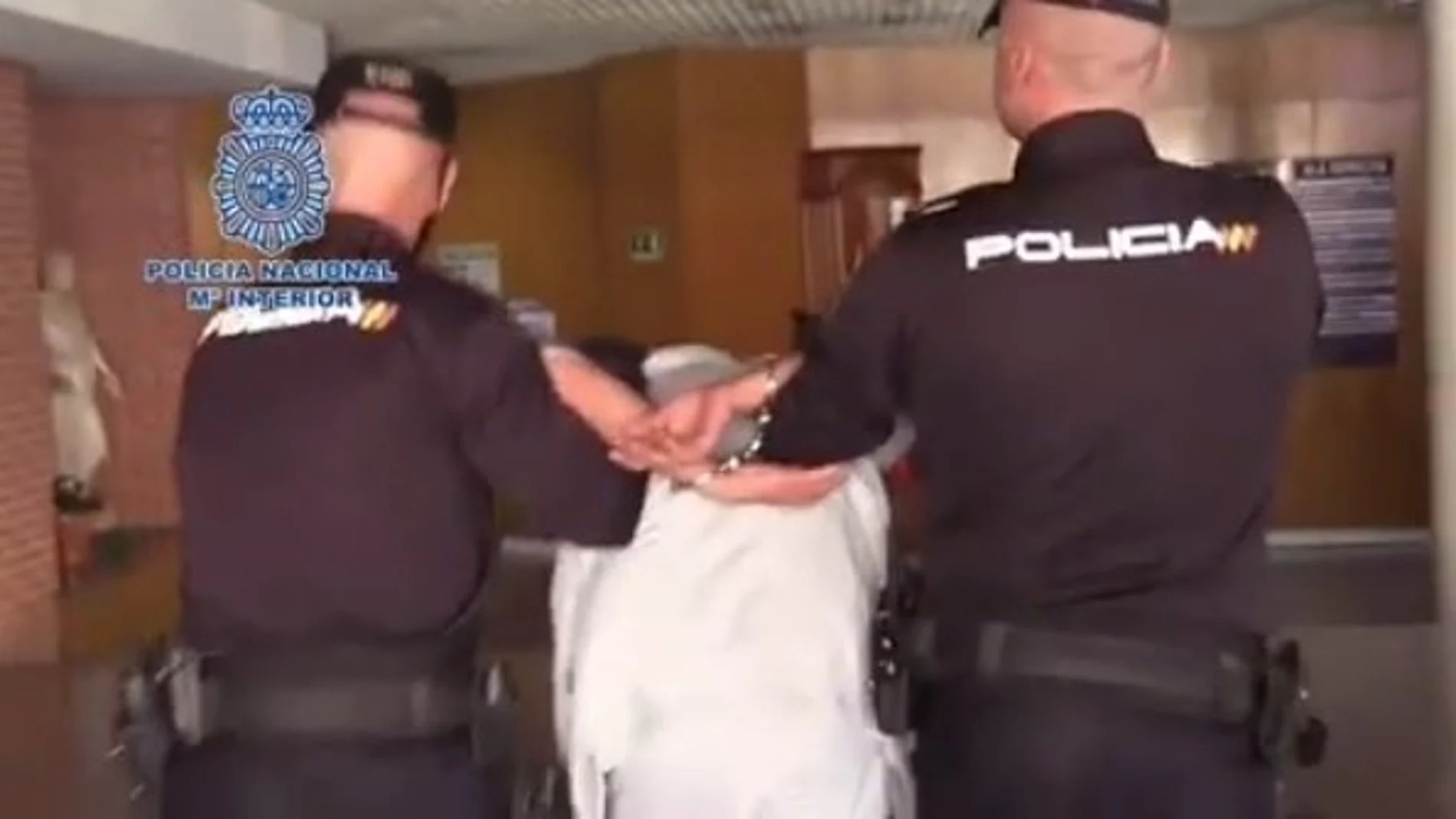 Dos policías conducen al detenido por un presunto asesinato en El Pozo (Vallecas).27/03/2019