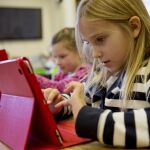 Dos niñas con un iPad en una escuela