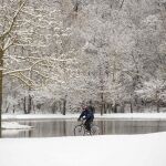 Un ciclista pedalea por la nieve en el parque de Olarizu de Vitoria.