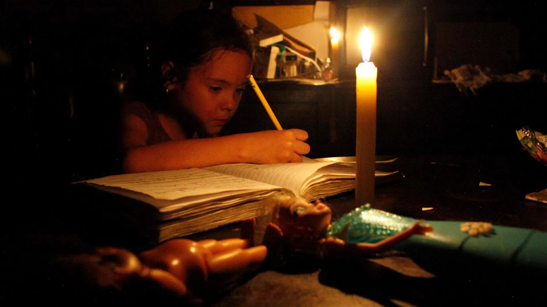 Una niña trabaja durante un corte eléctrico en una foto de archivo