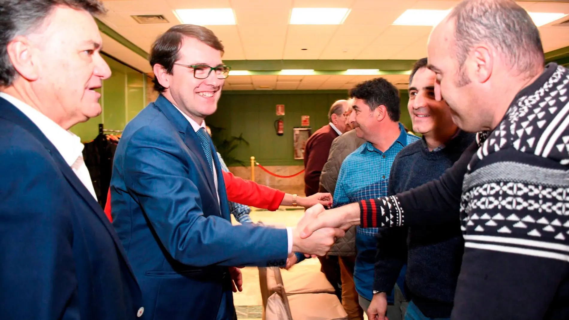Fernández Mañueco saluda a un simpatizante durante la convención del partido en Segovia, en presencia de Francisco Vázquez