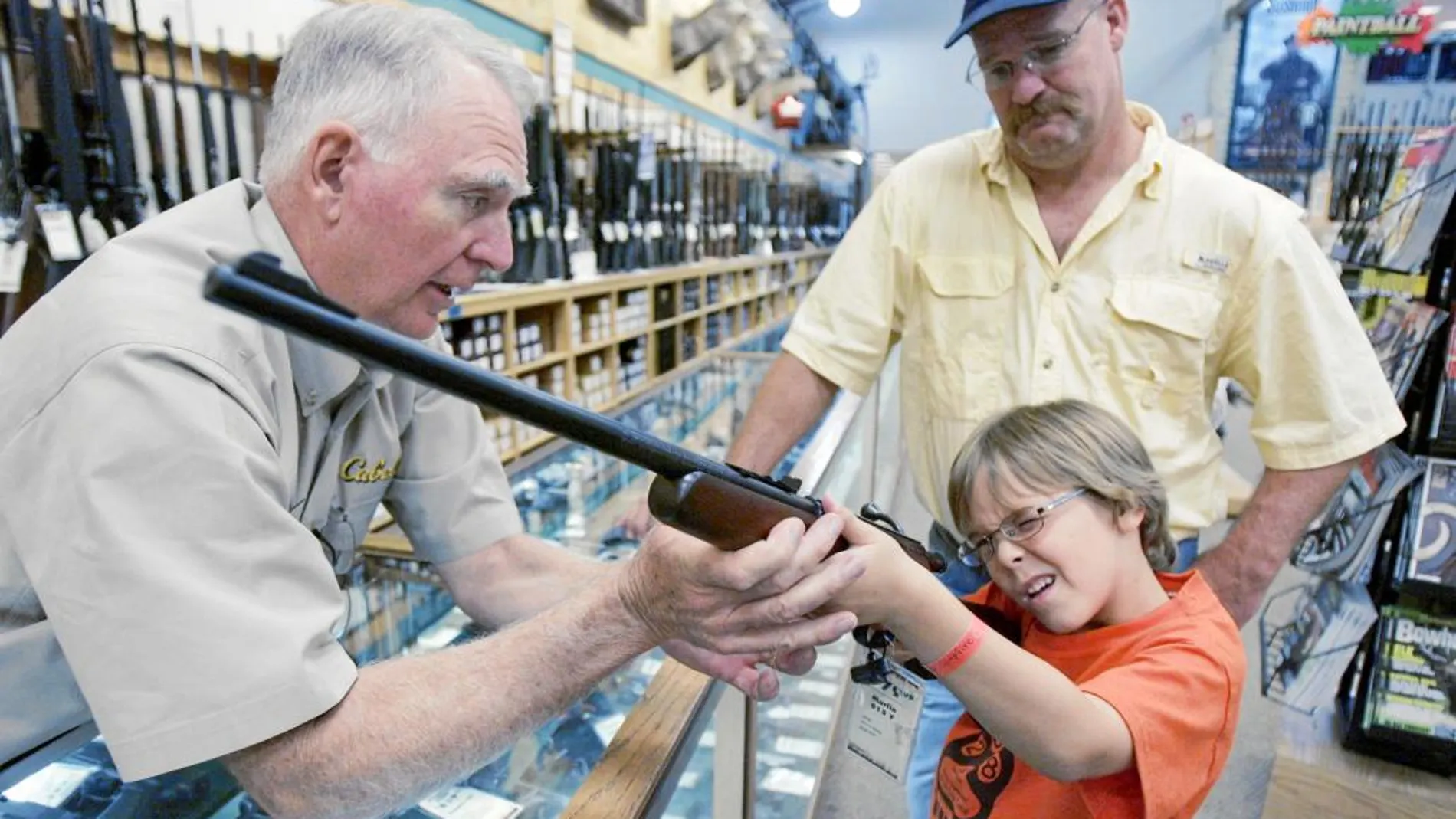 Un menor prueba un rifle en una armería de Dallas en compañía de su padre