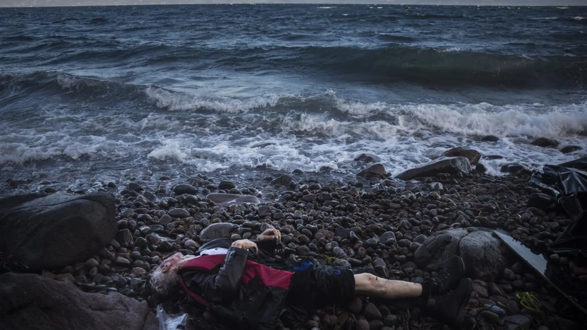 El cuerpo sin vida de un hombre es visto en una playa de Skala, en la isla griega de Lesbos, tras un naufragio el mes pasado