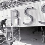 Operarios colocando un cartel de la URSS en la fachada de un recinto