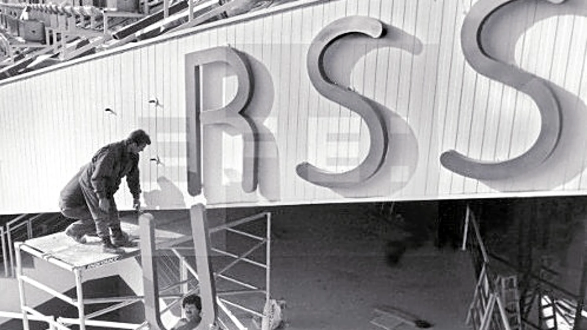 Operarios colocando un cartel de la URSS en la fachada de un recinto