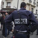 Un agente de policía permanece en guardia ante el bar le Carillon de París, Francia