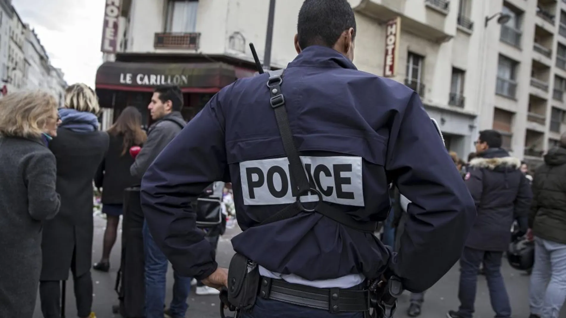 Un agente de policía permanece en guardia ante el bar le Carillon de París, Francia