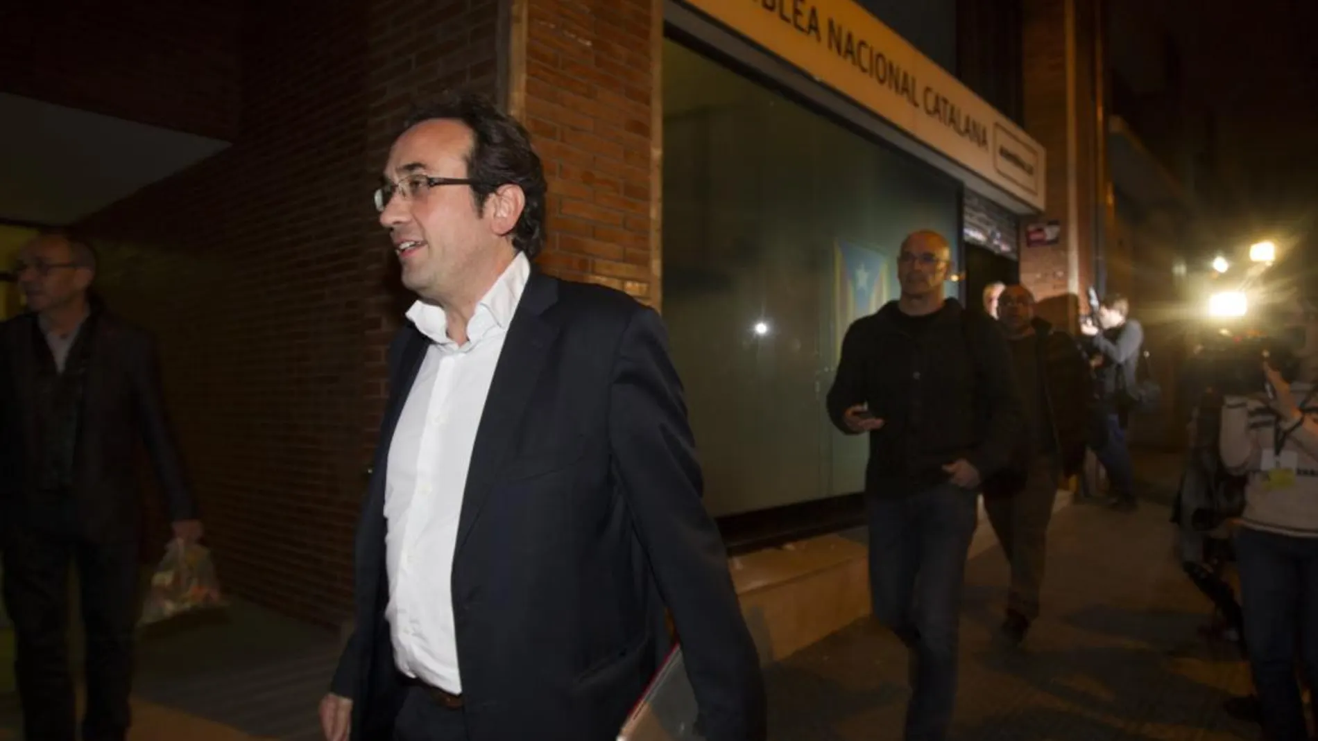Los dirigentes de Junts pel Sí, Josep Rull (i) y Raül Romeva (d) salen de la sede de la Asamblea Nacional de Catalunya (ANC) tras la reunión de hoy.