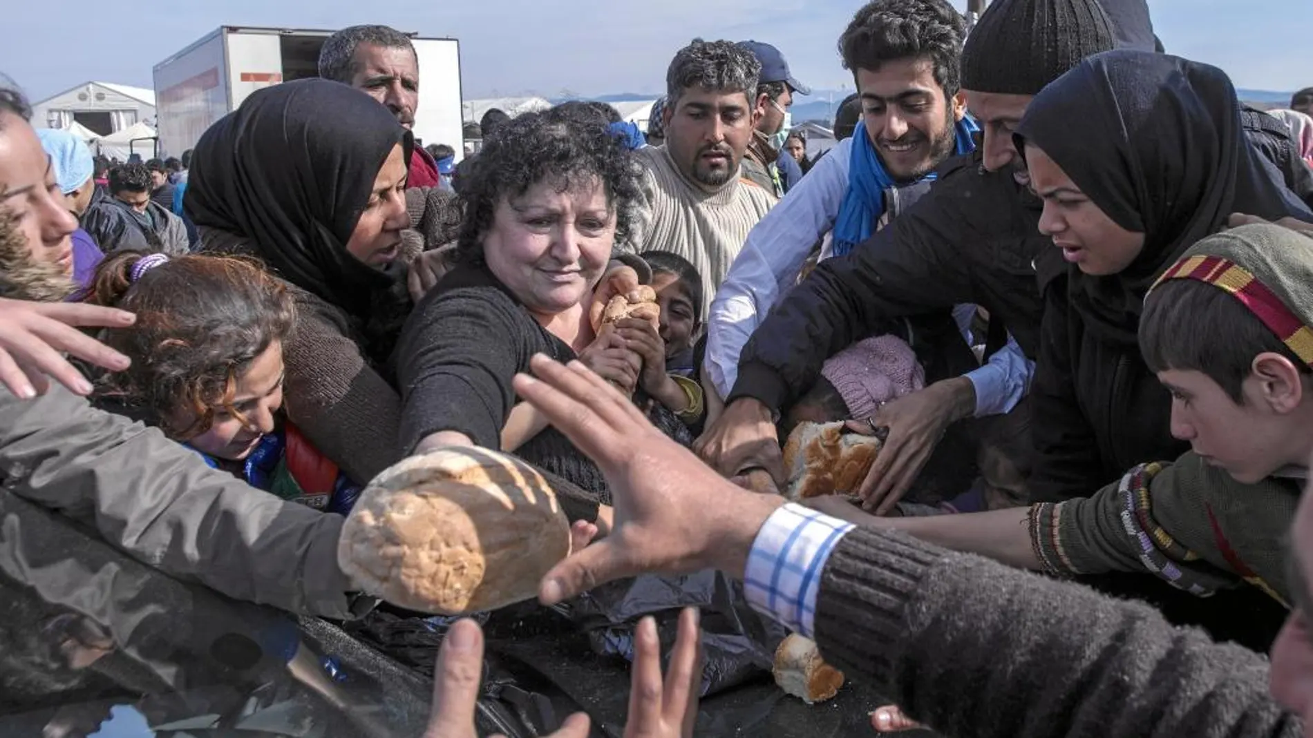 Varios inmigrantes acudieron al reparto de comida ayer en el campo de refugiados de Idomeni, en Grecia
