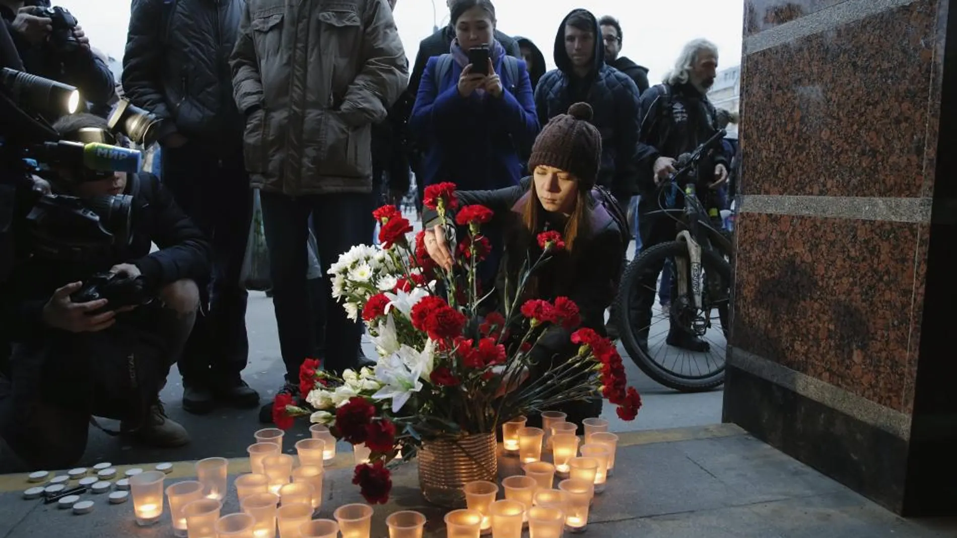 Varias personas depositan flores y velas por las víctimas del atentado terrorista ocurrido en el metro de San Petersburgo