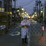 Un agente de seguridad monta guardia en una de las desérticas calles de la localidad de Naime, en el distrito de Futaba, al norte de la central nuclear de Fukushima