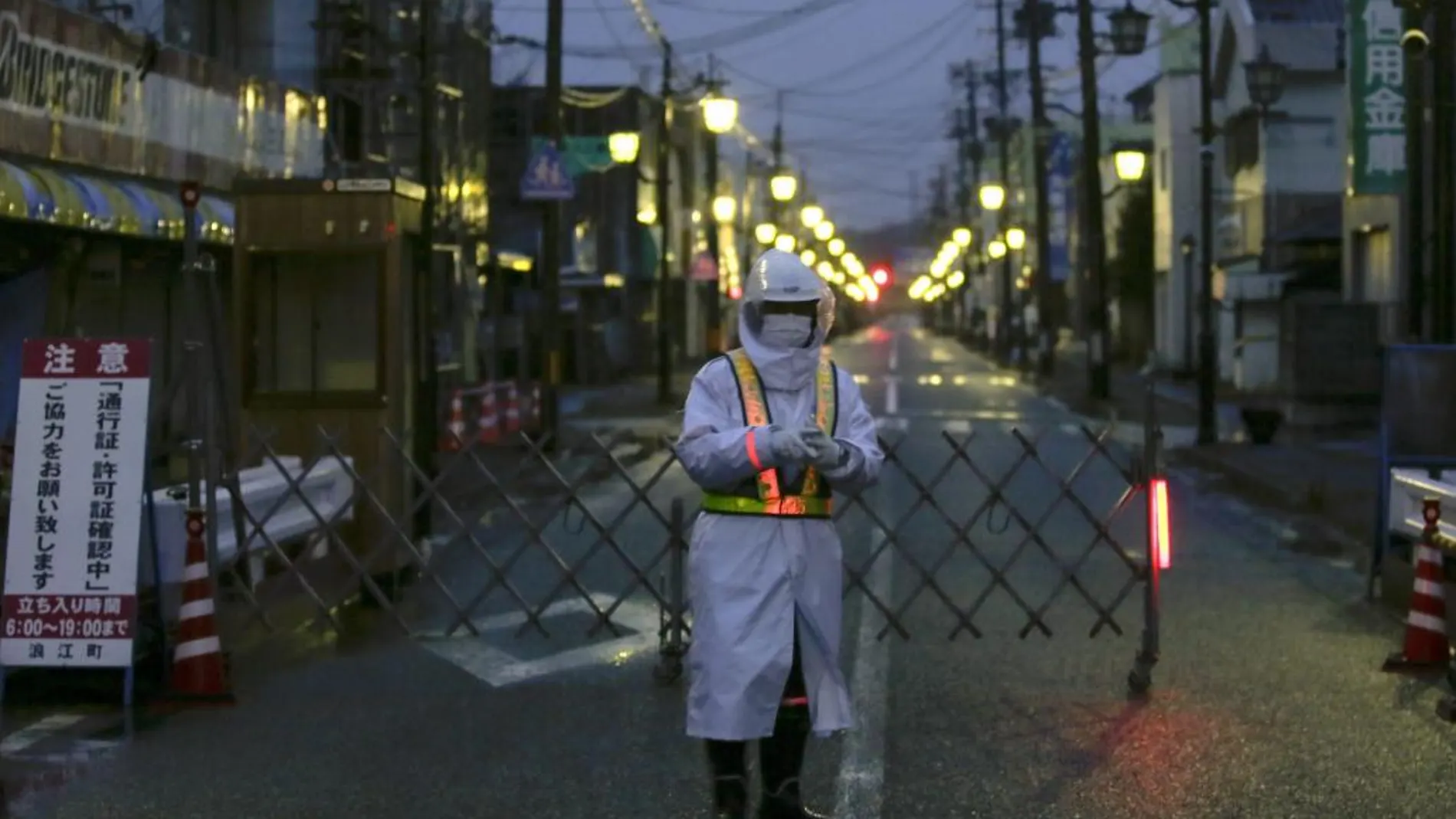 Un agente de seguridad monta guardia en una de las desérticas calles de la localidad de Naime, en el distrito de Futaba, al norte de la central nuclear de Fukushima