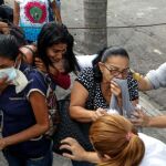 Un grupo de personas se protege durante un enfrentamiento entre manifestantes con la Guardia Nacional Bolivariana (GNB